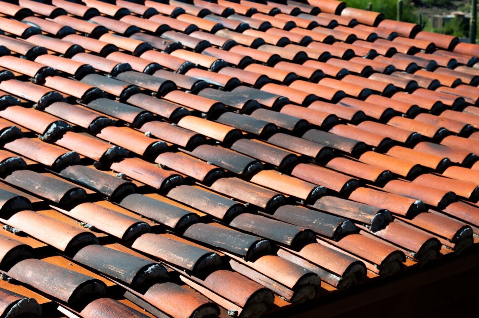 Close-up of weathered clay barrel roof tiles on an Arizona home in full sun