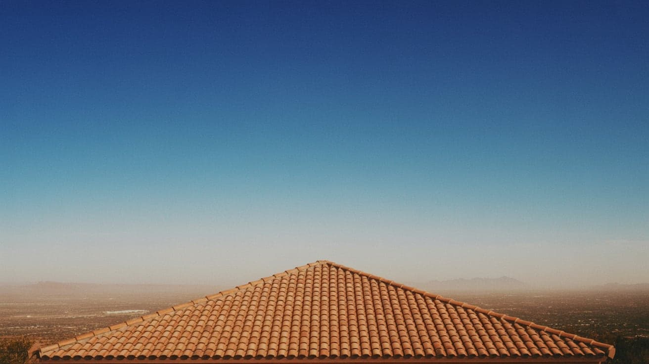 The terracotta tile ridge of an Arizona home against heat haze over the valley beyond