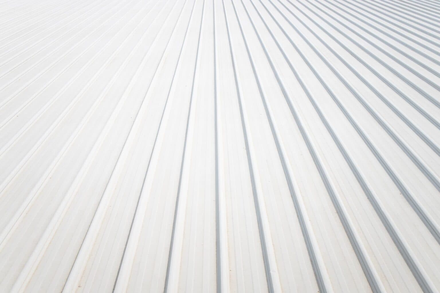 White standing-seam metal roof panels reflecting the desert sun