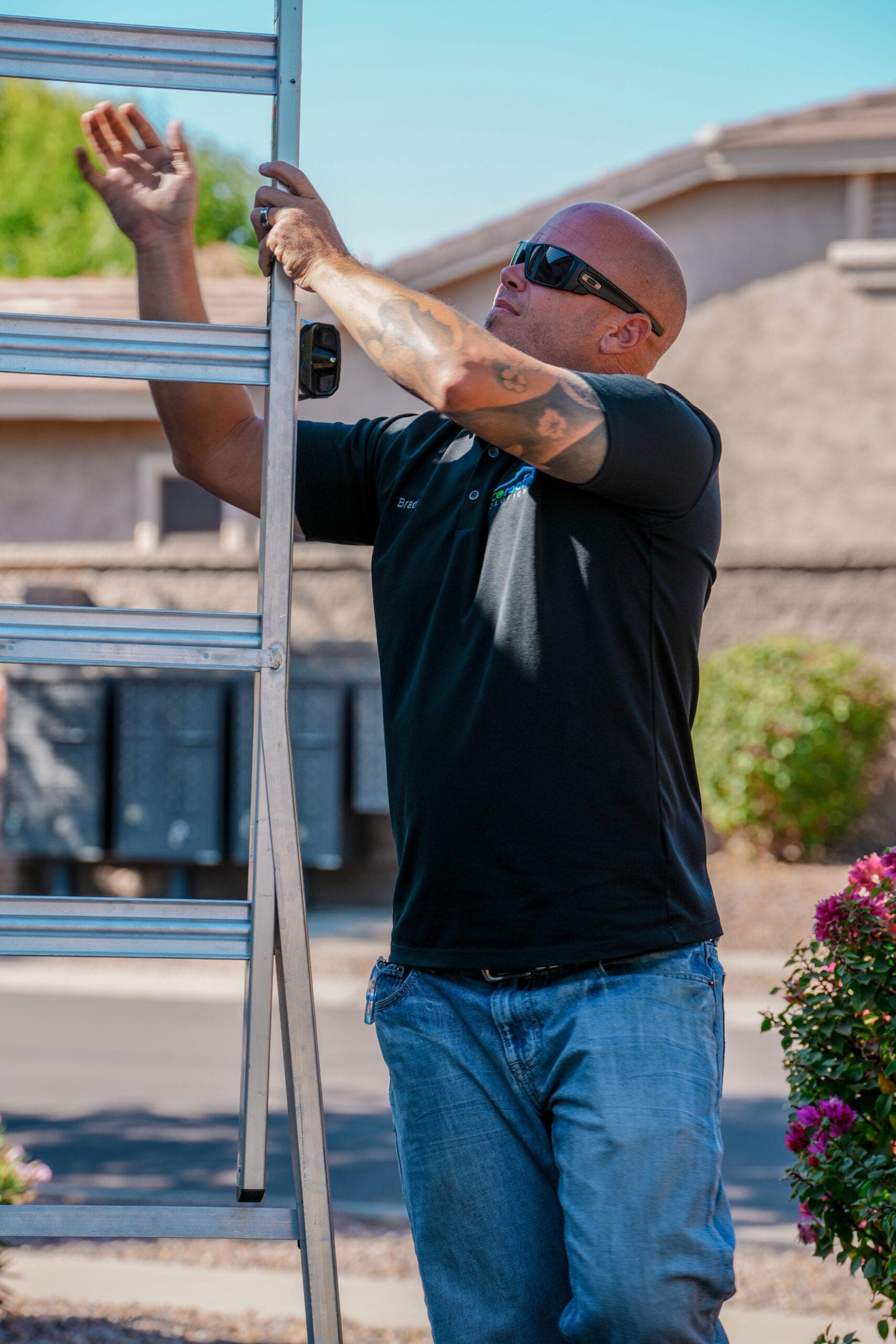 Eco Roofing Solutions team member raising an extension ladder against an Arizona home