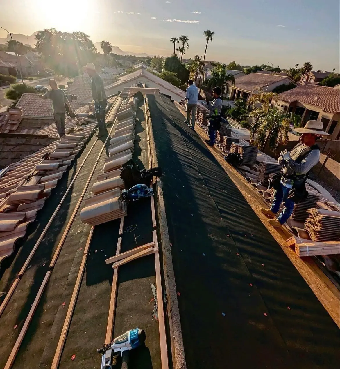 Eco Roofing Solutions crew stacking and setting concrete roof tile on an Arizona home at sunrise