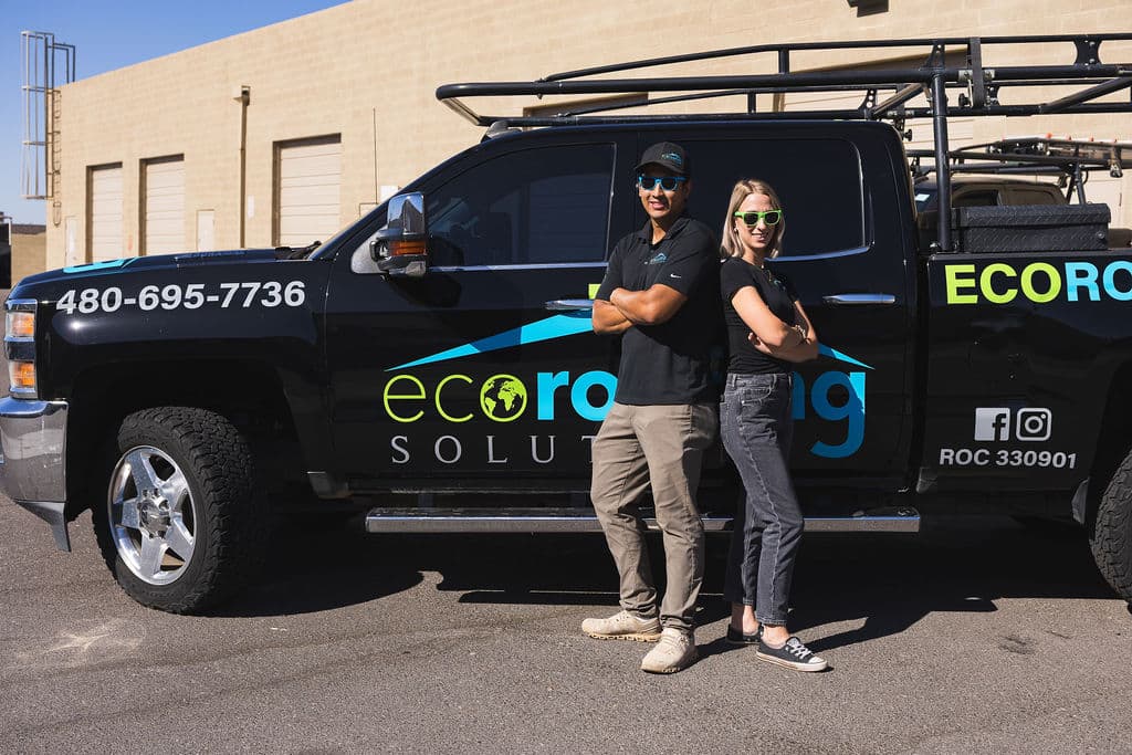 Two Eco Roofing Solutions team members standing in front of a branded company truck carrying the Arizona ROC license number