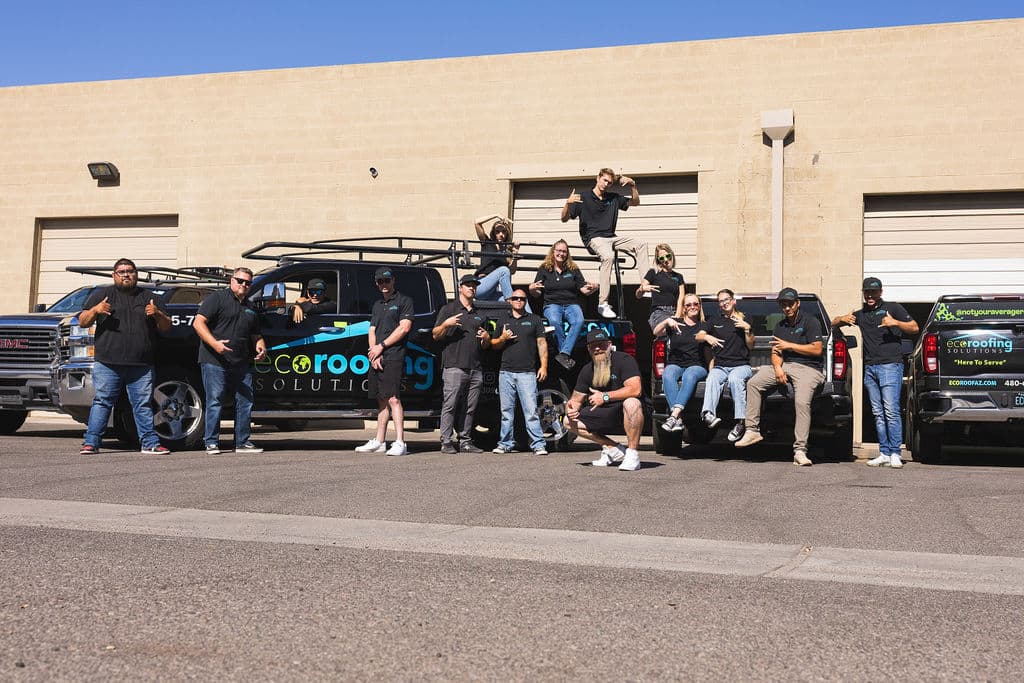 The full Eco Roofing Solutions team lined up in front of their branded trucks outside the Gilbert yard