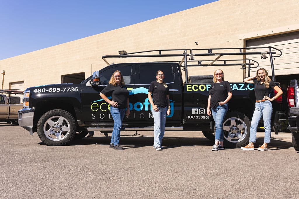 Four Eco Roofing Solutions office team members standing in front of a branded company truck at the Gilbert yard