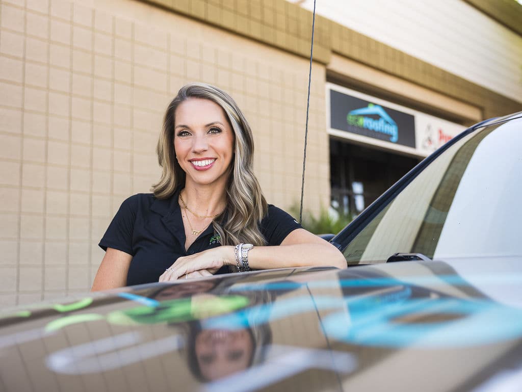 An Eco Roofing Solutions team member in a branded polo outside the company office in Gilbert, Arizona